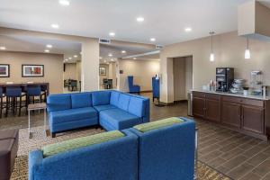 斯普林莱克Comfort Inn & Suites Spring Lake - Fayetteville Near Fort Liberty的一间带蓝色家具的客厅和一间厨房