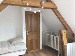 埃斯卡勒Ferme de la Haute-Escalles的一间设有婴儿床和木门的房间