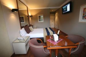 维戈机场汽车旅馆的酒店客房带一张床、一张桌子和椅子