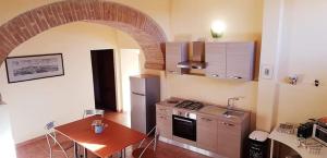锡耶纳Da Simone podere santi Lucia e Pietro的厨房配有桌子、炉灶和冰箱。
