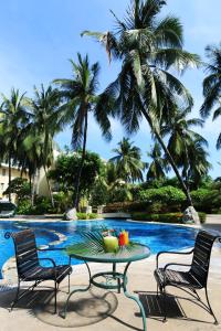 三亚三亚椰林滩大酒店 的一张桌子,上面有水果,放在游泳池前