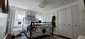 布鲁克林LUXE BROOKLYN Getaway的卧室配有黑色的床和白色衣柜。