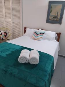 卡塔赫纳LA Perla Sabanera CTG的一间卧室配有一张床,上面有两条毛巾
