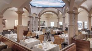 穆赫克雷斯的艾根Hotel Almesberger的餐厅设有白色的桌椅和蓝色的天花板