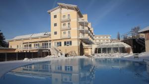 穆赫克雷斯的艾根Hotel Almesberger的雪地中的一座建筑,设有游泳池