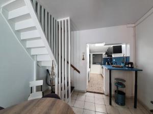 埃塔普勒RACINES MARINES的一间带楼梯的厨房和一间带桌子的厨房