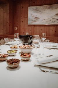 莱赫阿尔贝格Das Verwall - finest serviced apartments的餐桌,带食物盘和酒杯