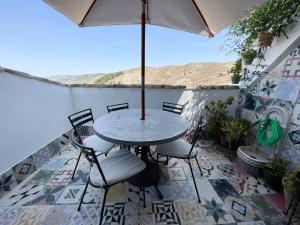 安特克拉Casa Vacacional Alcazabilla的庭院配有桌椅和遮阳伞。