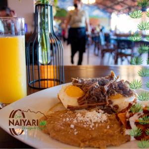 特皮克Casa Naiyari的一杯橙汁旁边的餐桌上的食物