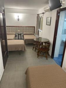 格拉纳达尤洛索尔旅馆的客房设有两张床、一张桌子和一张桌子。