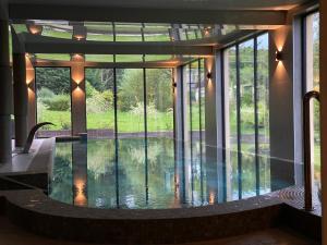 里沃Oasis Resort & Spa的一座带玻璃门的别墅中间的游泳池