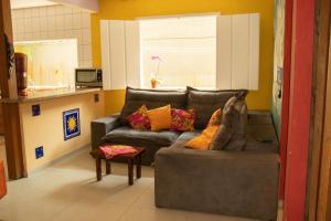 帕拉蒂Hostel Morada do sol Paraty的客厅配有带色彩缤纷枕头的灰色沙发