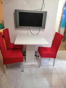 勒什Freya的一张带两把红色椅子的白色桌子和墙上的电视