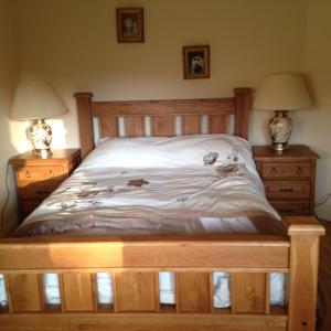 肯梅尔Golf Course View的一间卧室配有木床和2个床头柜