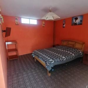 科帕卡巴纳阿雷格里港旅馆的一间设有床铺的卧室,位于一个拥有橙色墙壁的房间
