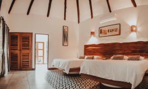 蒙特里科Dos Mundos Pacific Resort的卧室设有2张床和白色的墙壁。
