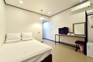 庆州卡萨迷你酒店的一间卧室配有一张床、一张书桌和一台电视