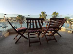 马尔萨斯卡拉Aquamarine Sea Front Apartments - Second Floor的阳台上配有两把椅子,享有海港景色