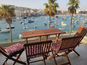 马尔萨斯卡拉Aquamarine Sea Front Apartments - Second Floor的一张桌子和两把椅子,享有海港的景色