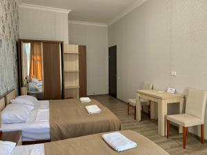 库塔伊西Hotel Red Bridge的酒店客房,设有两张床和一张桌子及椅子