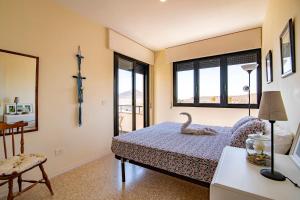 厄尔梅达诺Alquilaencanarias- Medano spectacular terrace and sea views B的一间卧室配有一张带天鹅的床