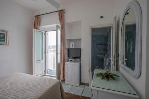 蓬扎格纳里诺滨海酒店的一间卧室设有一张床、一台电视和一个窗口。