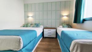 马斯帕洛马斯加那利花园俱乐部酒店的蓝色和白色的客房内的两张床