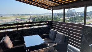 阿德勒阿莫索夫宾馆的阳台配有桌椅,享有机场美景。