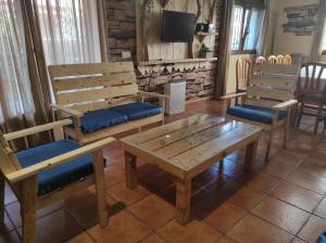 瓜达利斯-德拉谢拉Los Alisos Casa Rural的客房设有木长椅和桌椅。