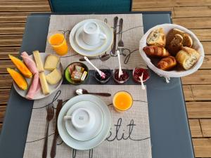 Orgnac-lʼAvenLe Petit Chêne的早餐桌,包括早餐食品和橙汁