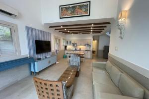 巴加Casa Legend Villa & Apartments Arpora - Baga - Goa的客厅配有沙发和桌子