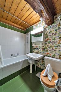 锡尔斯玛丽亚Chesa La Cuntainta - Sils Maria的带浴缸、盥洗盆和卫生间的浴室