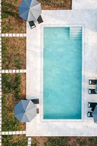 Paralía IríonIrissa Suites的享有带遮阳伞的游泳池的顶部景致