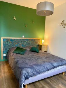 阿斯克新城Appartements du 101的一间卧室设有一张大床和绿色的墙壁