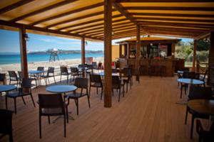 奥马斯帕纳吉亚斯Meltemi的海滩上带桌椅的餐厅
