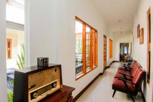 日惹S5 Guest House Yogyakarta的客厅配有电视和一些椅子