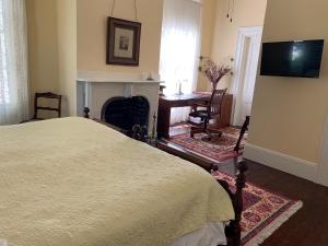 蒙蒂塞洛1872 Denham Inn的一间卧室配有一张床和一个壁炉
