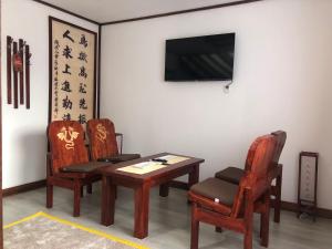 锡吉什瓦拉Casa Lily - Japanese Retreat的一间设有两把椅子、一张桌子和一台电视的房间