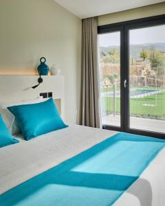 HuénejaHotel Boutique Molino de Enmedio的一间卧室配有一张带蓝色枕头的床和一扇窗户。