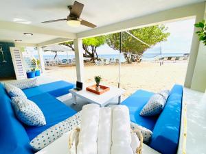 瓦利Sandcastle Villa & Beach House的海滩上带蓝色和白色家具的庭院