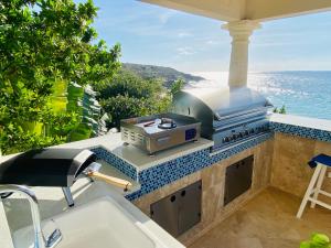 瓦利Sandcastle Villa & Beach House的海景户外厨房配有烧烤架