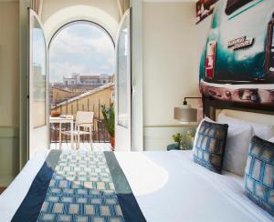 罗马Hotel Indigo Rome - St. George, an IHG Hotel的一间卧室设有一张床,享有阳台的景色