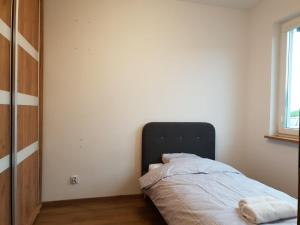 斯塔加德什切青Apartament Podmiejska Stargard的卧室位于客房的角落,配有一张床