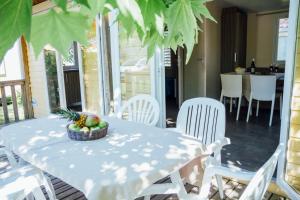 吉索纳恰维尼亚莱度假酒店的一张桌子、白色的椅子和一碗水果