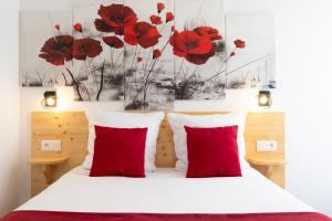 朗戈涅hotel le beauséjour的卧室配有红色枕头和墙上的红色罂粟