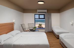 特拉维夫180 Boutique Hostel的一间带两张床的卧室,享有海滩美景