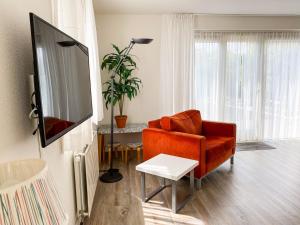 布雷斯肯斯Hello Zeeland - Vakantiehuis Zwin 182的客厅配有橙色沙发和电视
