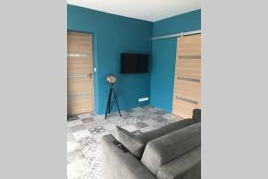 伊索勒河畔贝斯Logement attenant à une villa T2 avec terrasse .的带沙发和蓝色墙壁的客厅