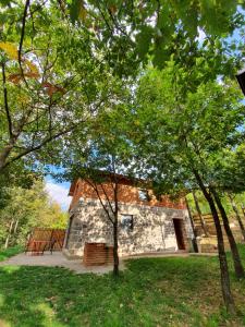 NovoberdoLura Agroturizem的一座石头建筑,位于一个树木繁茂的公园中