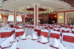 赫梅利尼茨基所博科夫酒店的宴会厅配有白色桌子和红色椅子
